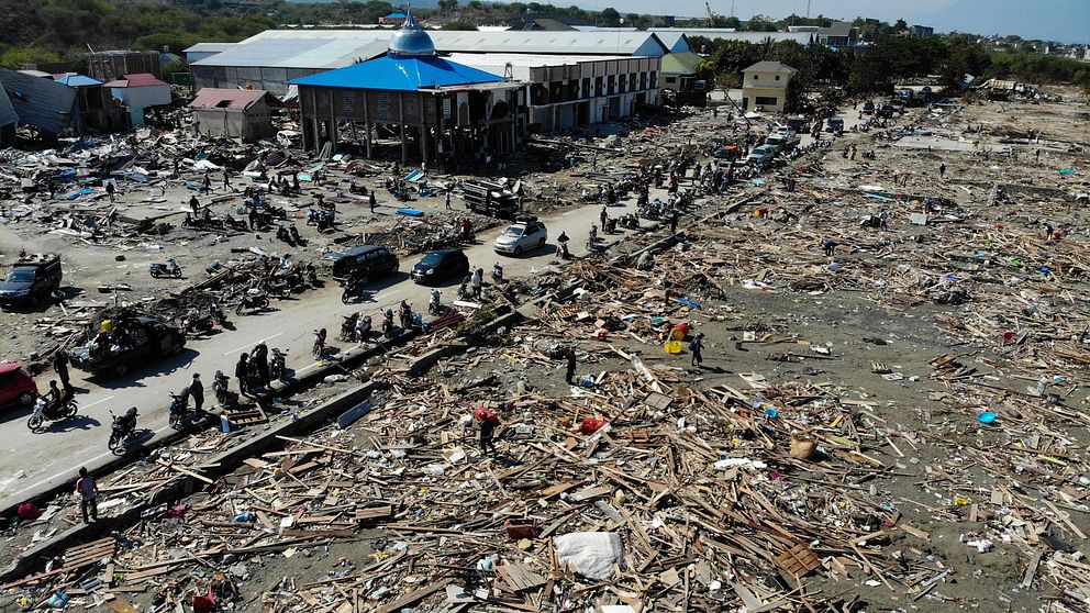 Överlevande söker efter användbara föremål i ruinerna i Palu, Indonesien.
