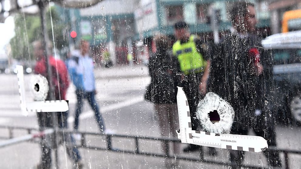 Kulhål i fönstret på Drottninggatan i Malmö dagen efter att tre personen skjutits till döds på öppen gata i anslutning till ett internetcafé.