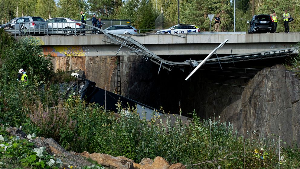 Bussolyckan i finska Kuopio – vy över polis och bilar på bron, trasigt räcke, del av bussen syns ligga på sidan i ravin cirka 10 meter nedanför