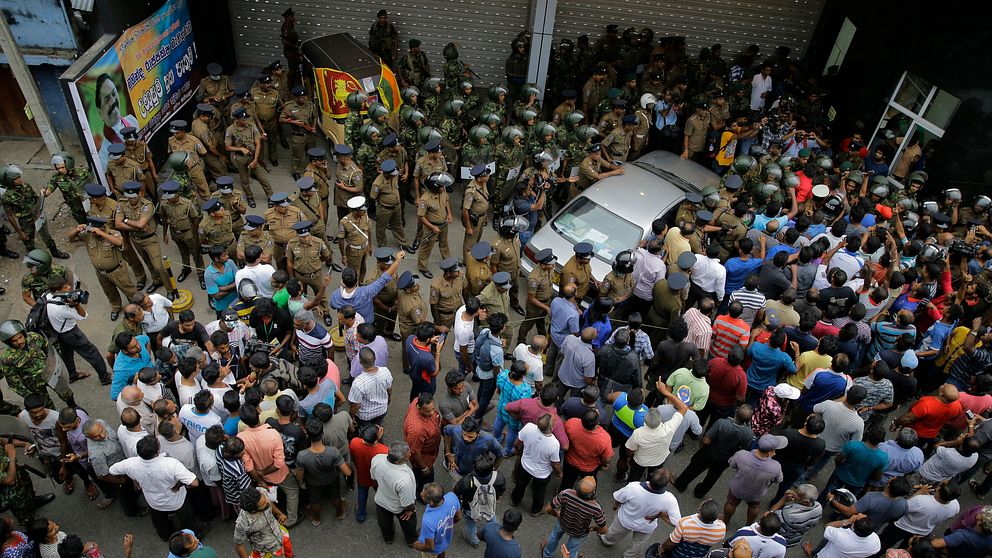 Säkerhetsstyrkor utanför Arjuna Ranatungas kontor efter dödsskjutningen under söndagen.