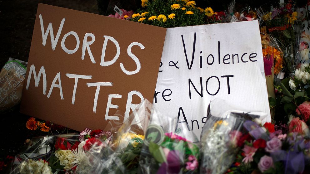 Plakat med texten ”ord har betydelse” bland blommor utanför synagogan Tree of Life i Pittsburgh