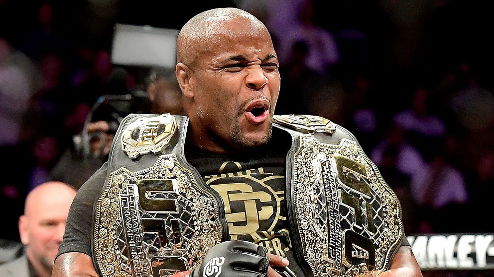 Daniel Cormier, 39, jublar med sina två mästarbälten.