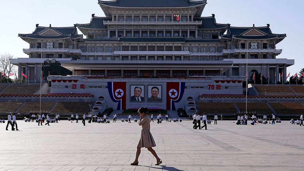 Kvinna går över stort torg i Pyongyang.
