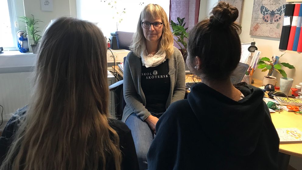 Skolsköterkan Katarina Andersson pratar med två elever.