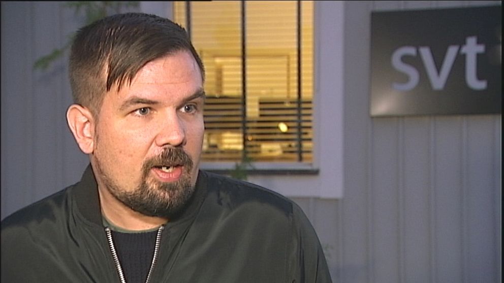 Philip Naskret, reporter på SVT, utanför hus med SVT-logga