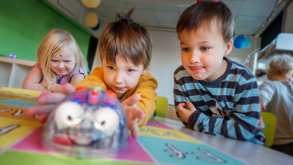 Wilma Verle 5 år, Edwin Åsåker 5 år och Albin Ullström 4 år försöker programmera roboten att gå dit de vill.