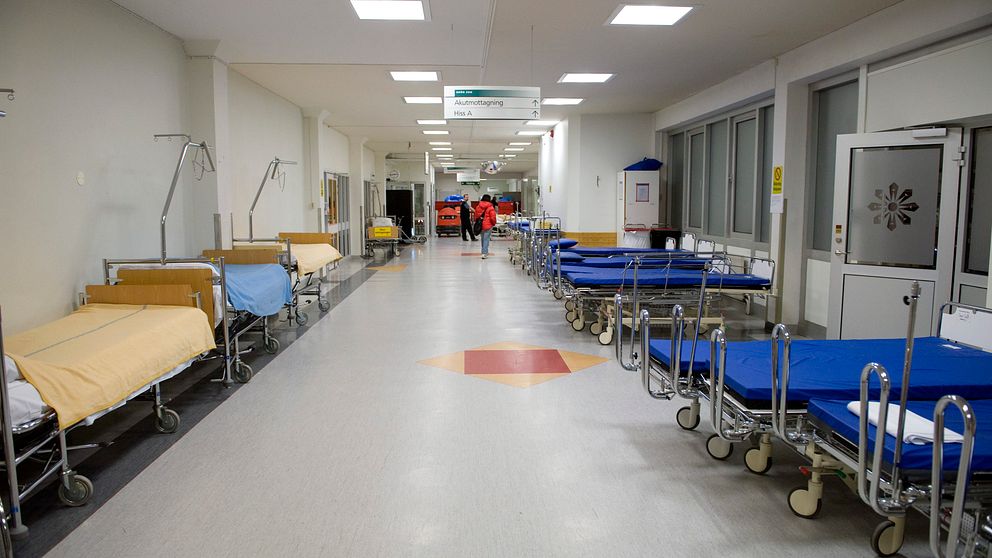Tomma sjukhussängar i en korridor.