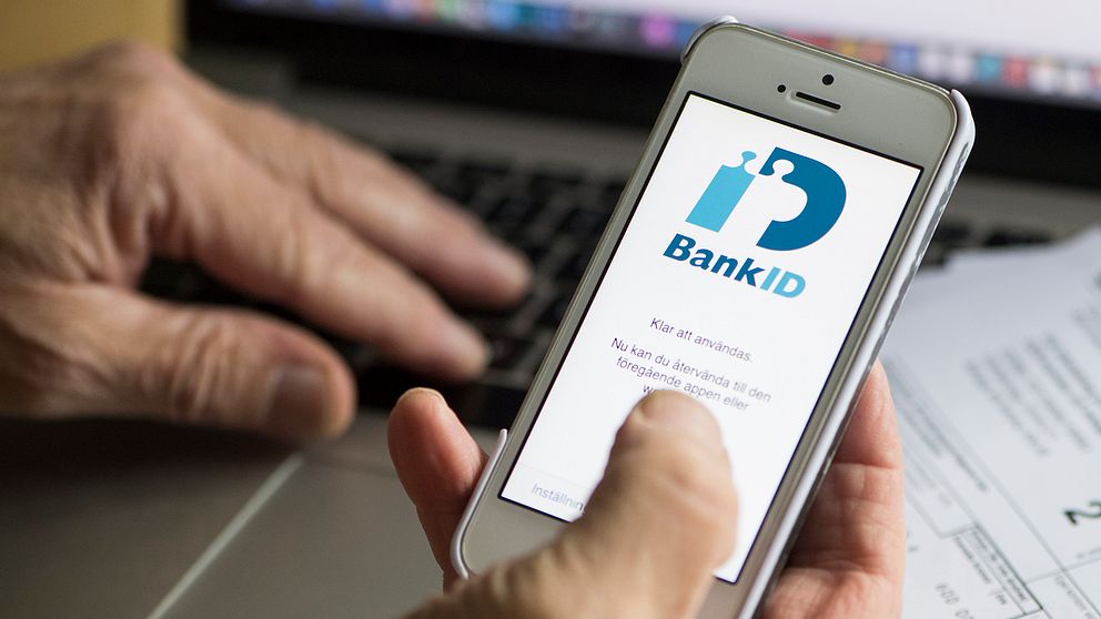 En man betalar räkningar digitalt på nätet med hjälp av bank-id.