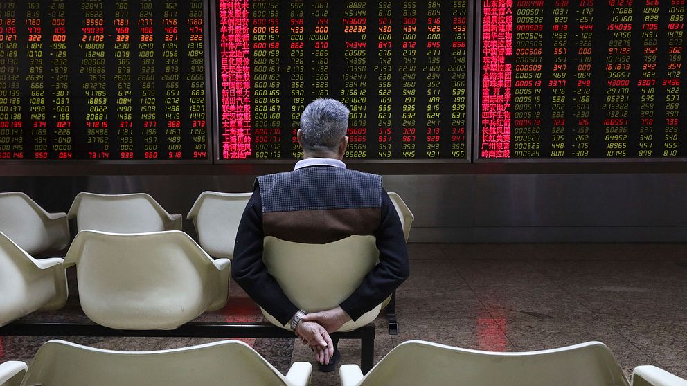En man tittar på aktiekurser i Peking