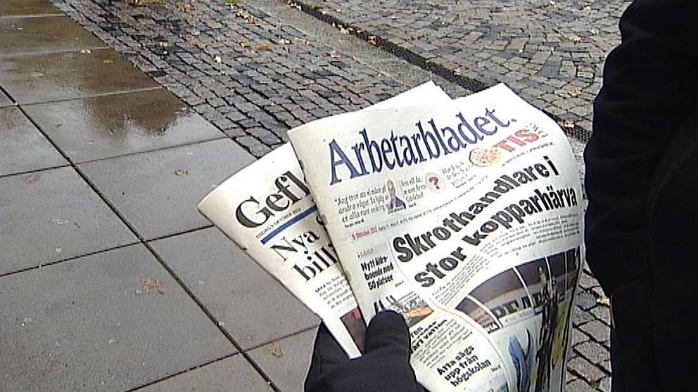 någon håller två tidningar ute på gatan: Gefle dagblad och Arbetarbladet