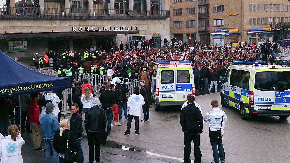 Polisen motar bort 100-tals motdemonstranter från Götaplatsen, där SD försöker hålla valmöte med Jimmie Åkesson. Mötet har hindras med talkörer, burop och musikinstrument.