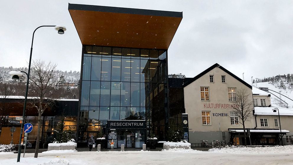 Entrén till resecentrum, det snöar och är vitt på gatan framför. Kulturfabrikens byggnad syns till höger.