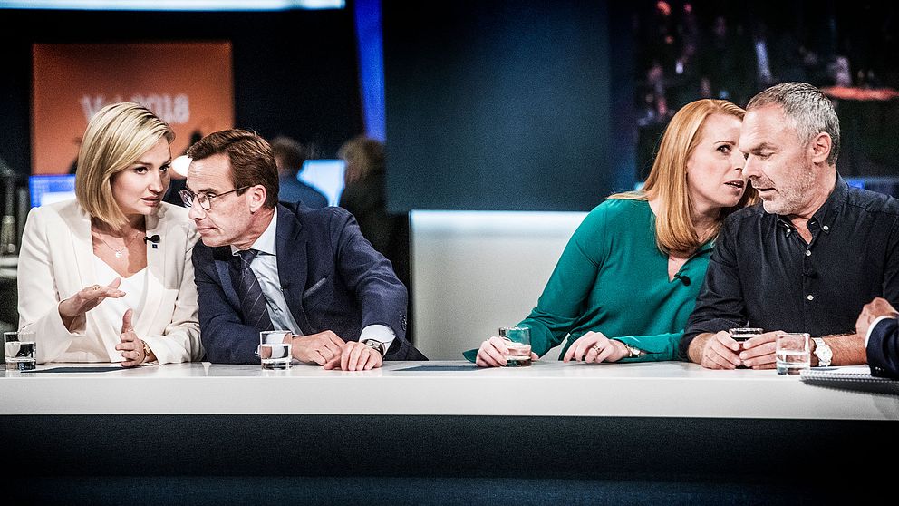 Ebba Busch Thor (KD) och Ulf Kristersson (M) viskar till varandra på SVT:s valvaka.