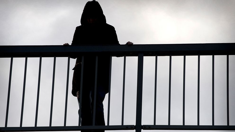 En kvinna står på en bro.