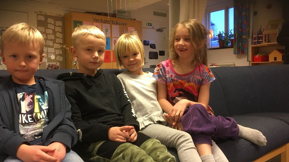 En bild på fyra barn i en soffa.