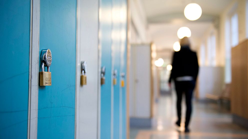 En elev går i en skolkorridor.