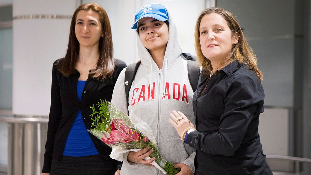 Rahaf al-Qunun, 18, anlände till Toronto flygplats under lördagen och hälsade pressuppbådet tillsammans med Kanadas utrikesminister Chrystia Freeland (höger)