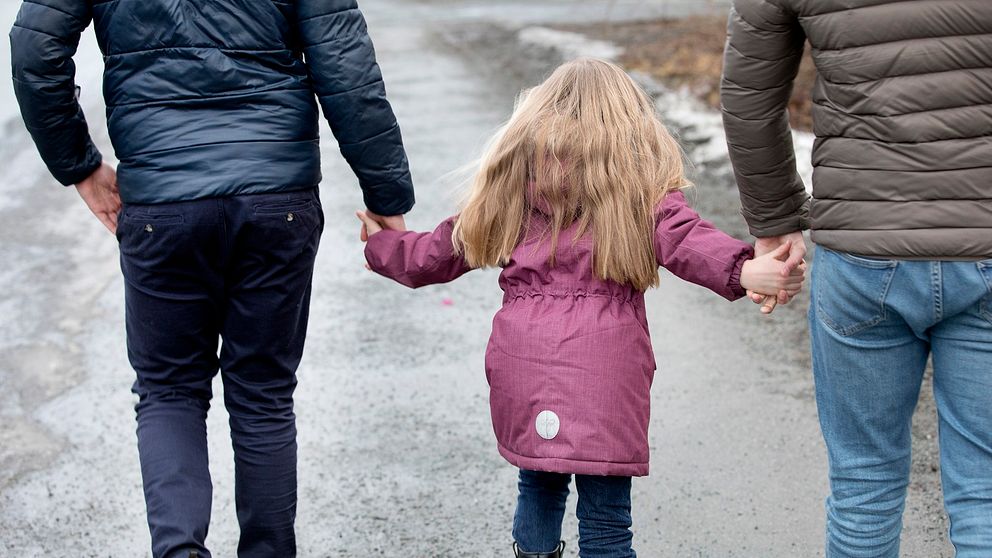 Föräldrar som går med barn i handen.