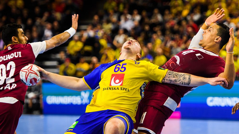 Lukas Nilsson får en smäll i Sveriges match mot Qatar i handbolls-VM.