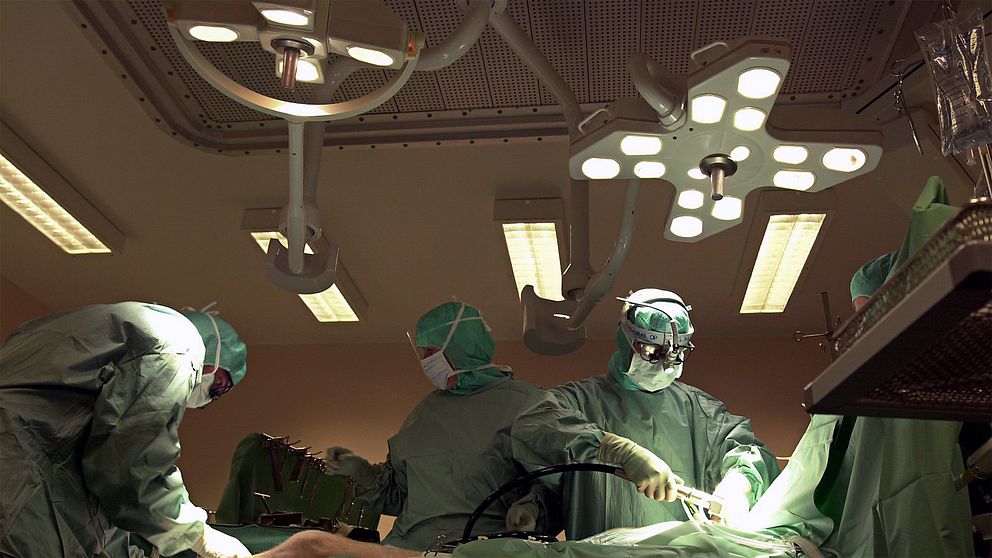 Läkare opererar i operationssal med lampor