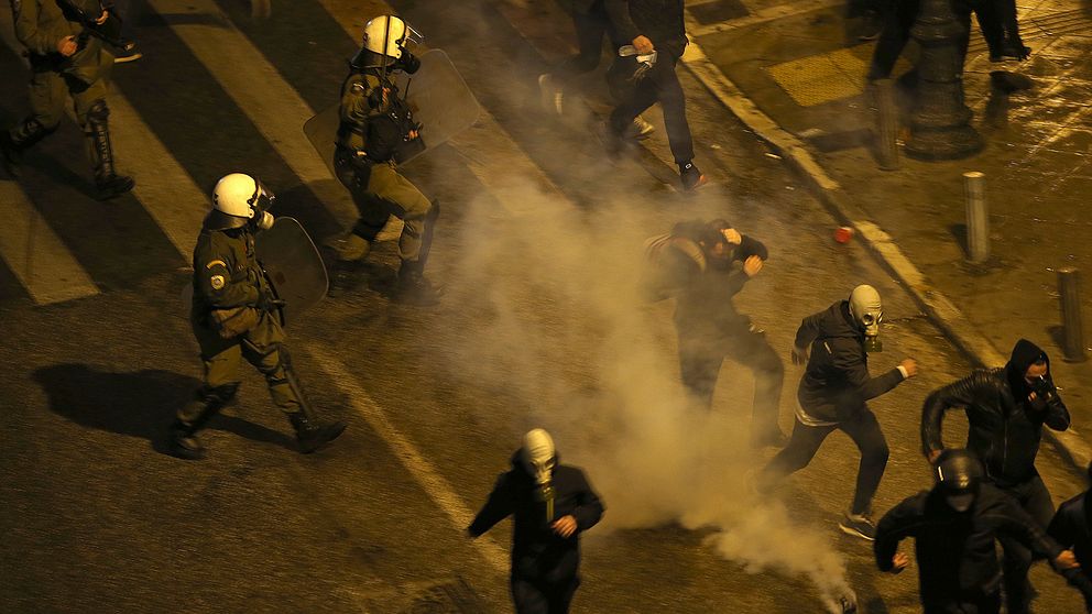 Grekisk polis kastas tårgas mot demonstranter utanför parlamentet i Aten.