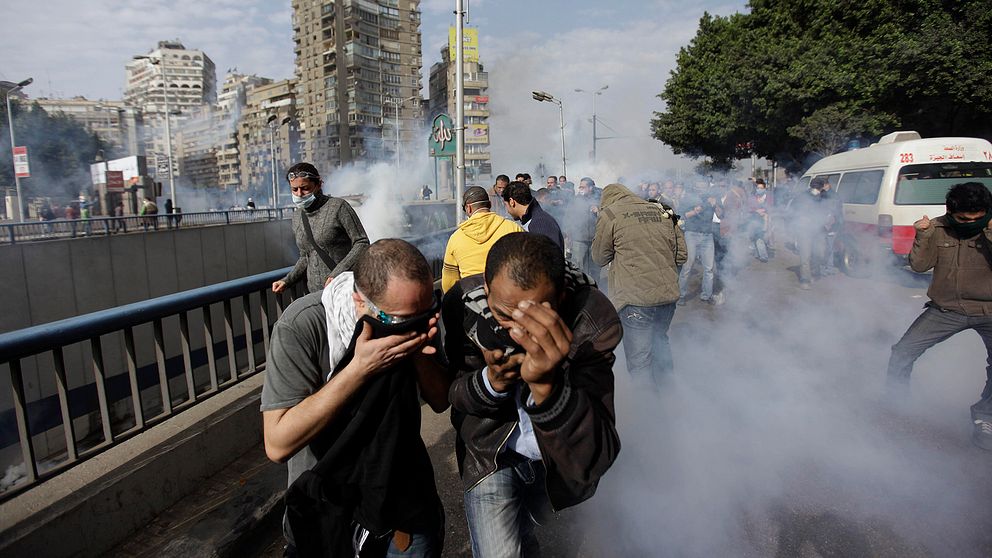 Män flyr undan tårgas i Egypten.