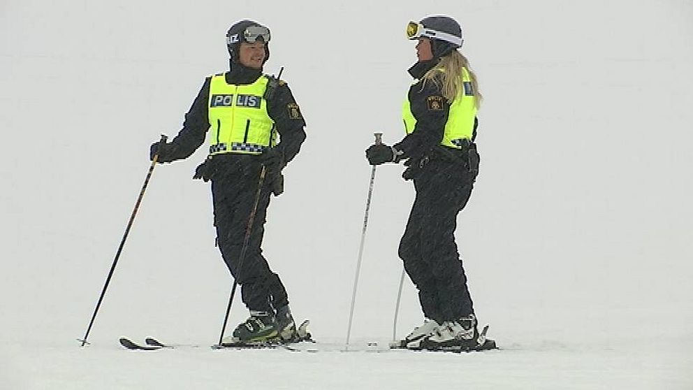 två poliser på slalomskidor i snöväder