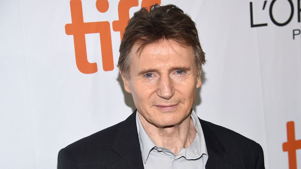 Liam Neeson poserar framför kameran.