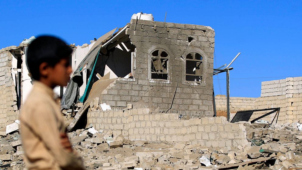 Ett barn bredvid ruinerna av ett bombat hus i Jemens huvudstad Sanaa.