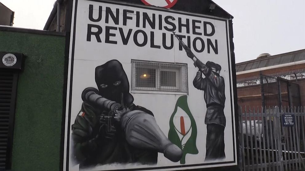Väggmålning med maskerade men med raketgevär och texten unfinished revolution