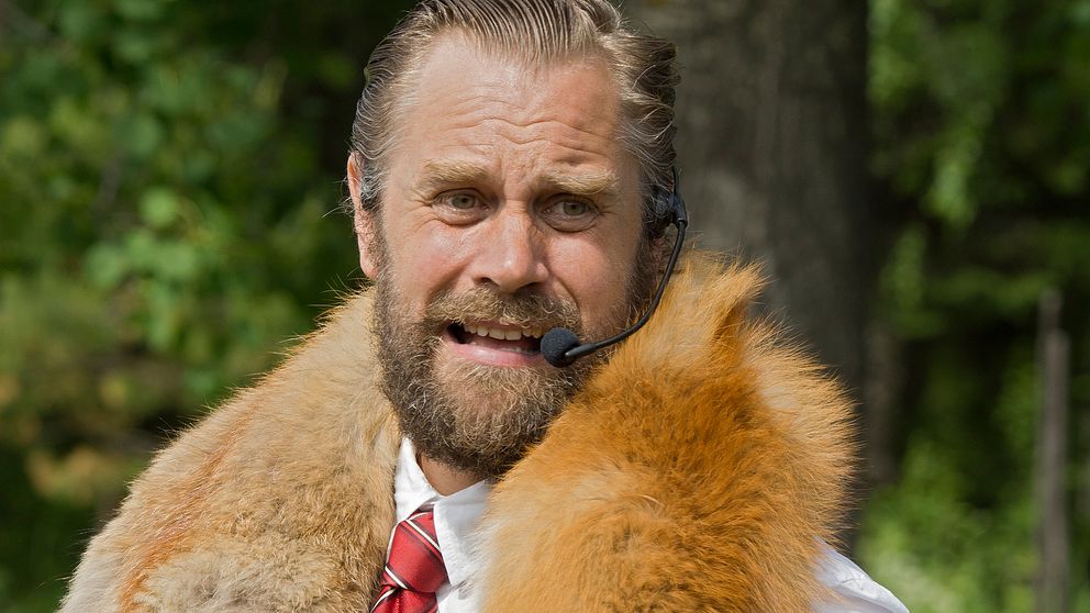 en man med slips och stor pälskrage