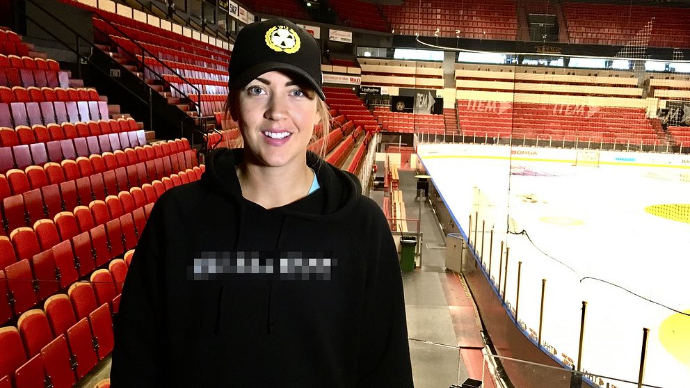 porträtt på en tjej som står på läktaren i hockey-arena