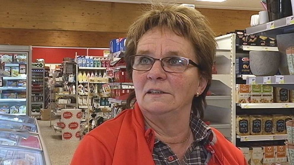 Kvinna i glasögon och röd jacka intervjuas i butiksmiljö. Kvinnan är Birgitta Gullbrandsson, affärsinnehavare i Rossön