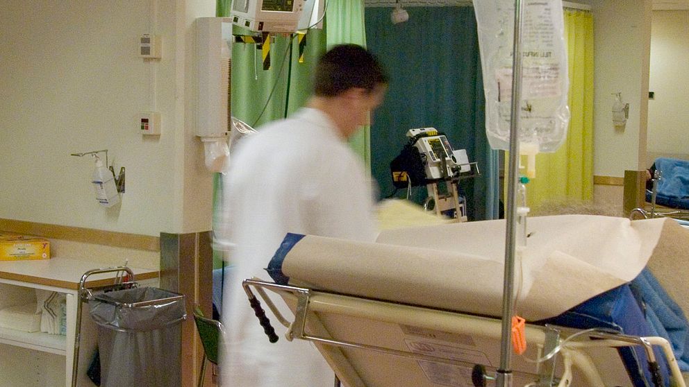Läkare som skyndar genom sjukhuskorridor.
