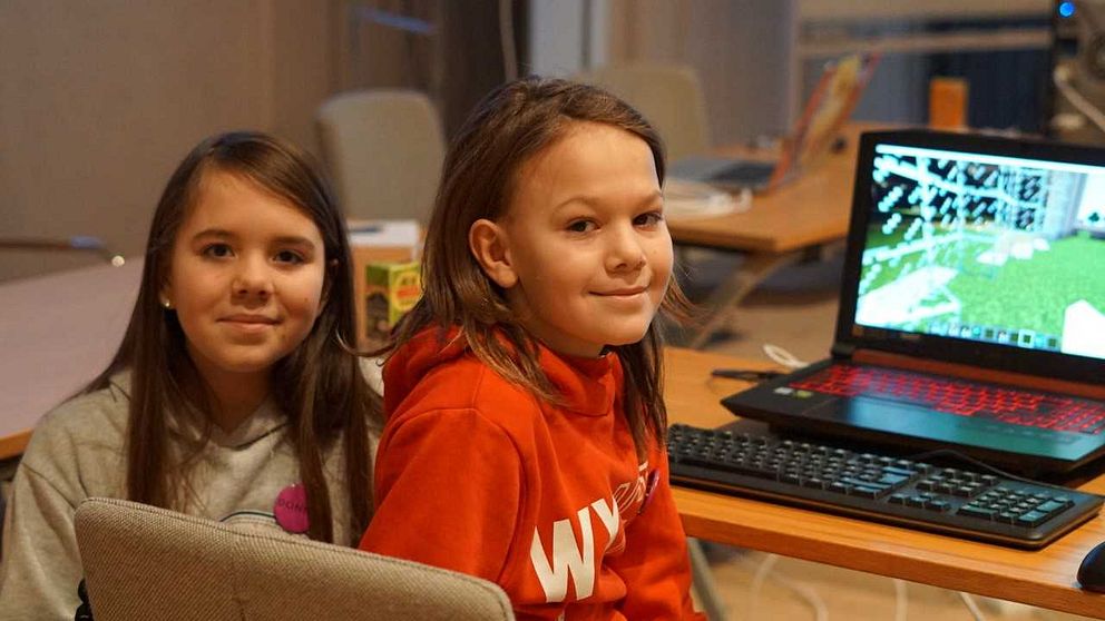 en flicka och en pojke spelar dator