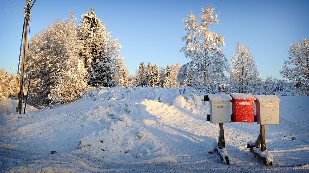 tre postlådor i vinterlandskap.