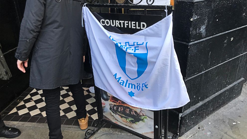 Malmö FF-flagga över en pubskylt.