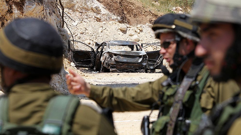 Israeliska soldater vid en bil som misstänks ha koppling till de försvunna tonåringarna.