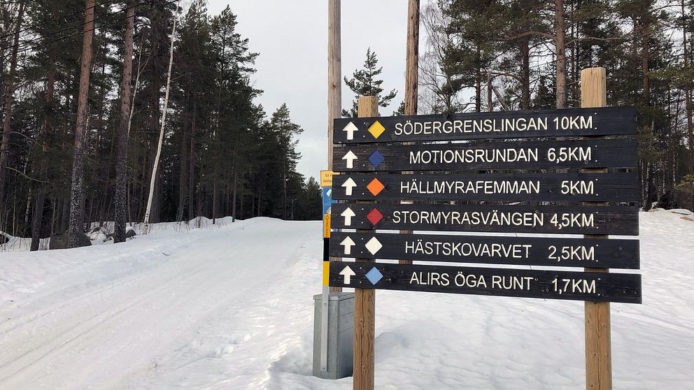 Skidspår i backe. Med skylt som visar olika namn på skidspåren