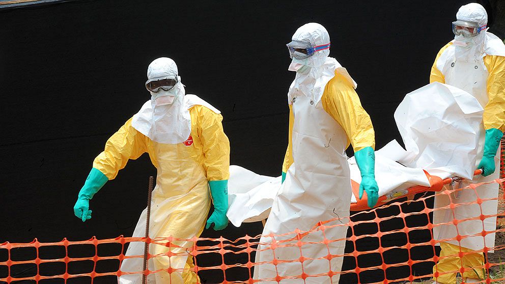 Personal från Läkare utan gränser bär ut kroppen av en person som avlidit i ebola i Guekedou i Guinea.