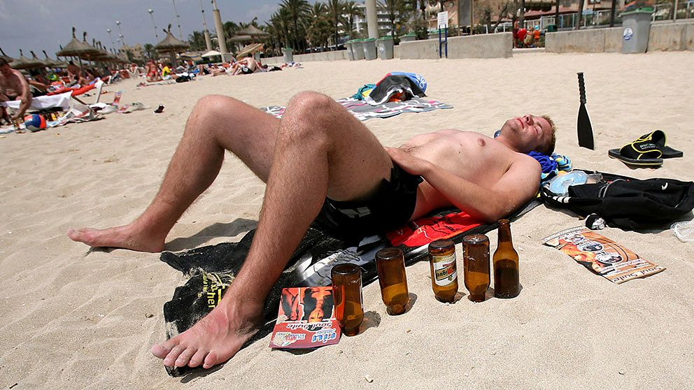 En tysk turist tar igen sig efter intensivt öldrickande på Arenalstranden i Palma de Mallorca.