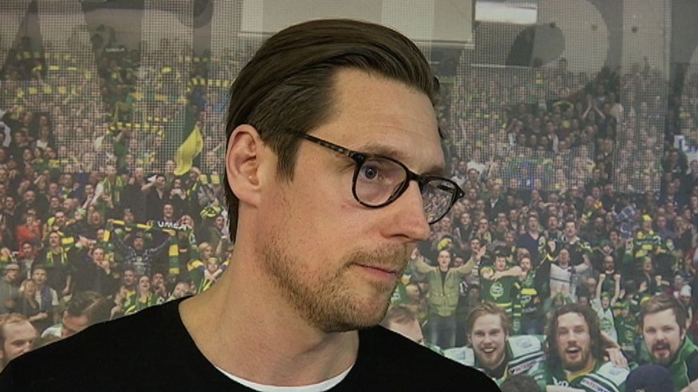 en man med brunt hår och rundade svartmelerade glasögon