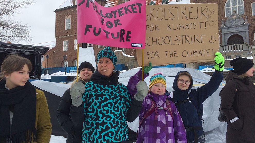 Barn och vuxna med plakat om skolstrejk för klimatet utanför Rådhuset i Östersund