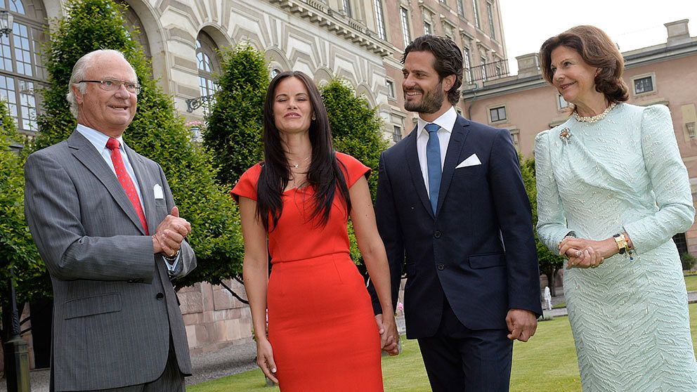 Kung Carl XVI Gustaf, Sofia Hellqvist, prins Carl Philip och drottning Silvia poserar vid ett pressmöte på Logården till Stockholm Slott på fredagen sedan prinsen och Hellqvist förlovat sig.