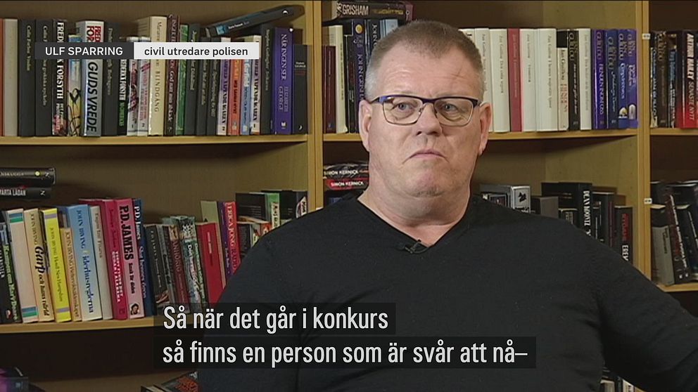 Ulf Sparring, polisens civila utredare, sitter i svart v-ringad tröja. i bakgrunden står en bokhylla full med böcker.