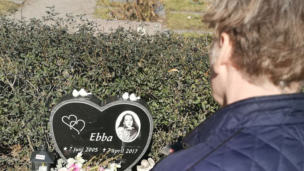 Stefan står framför dottern Ebba Stefansdotter Åkerlunds grav. Gravstenen pryds av en bild av Ebba.
