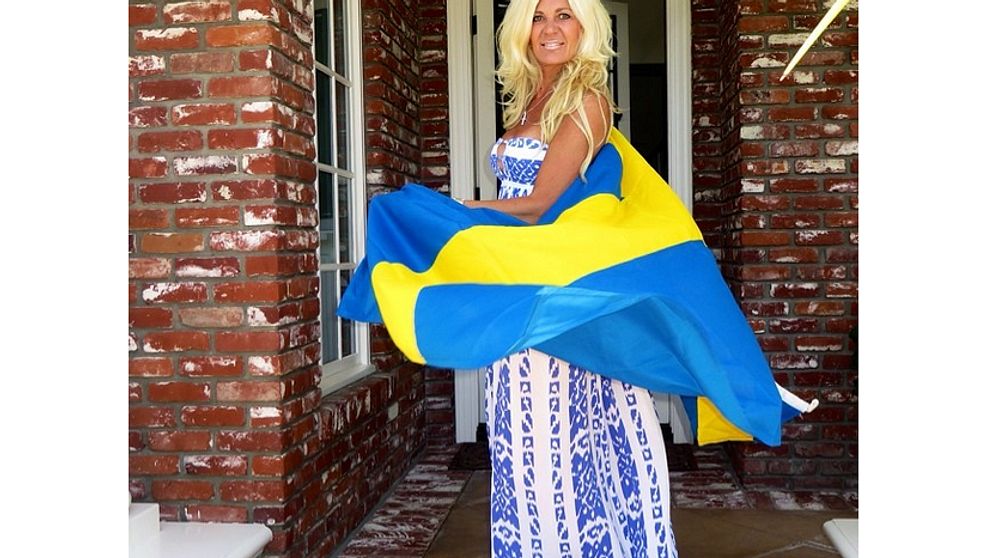 Maria Montazami deltar i #minsverigebild och delar en bild av sig själv insvept i svenska flaggan.