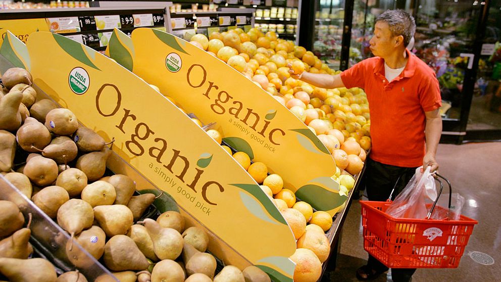 FILE – In this June 15, 2007, file photo, a customer picks out fruit while shopping at the Hannaford Supermarket in Quincy, Mass. The United States and Japan have agreed to make it easier to import each other's organic products, the latest step in a global effort that could give consumers more, and cheaper, access to organic food. The Agriculture Department is planning to announce Thursday, Sept. 26, 2013, that organic products certified in Japan or in the United States may be sold as organic in either country. (AP Photo/Stephan Savoia, File)q