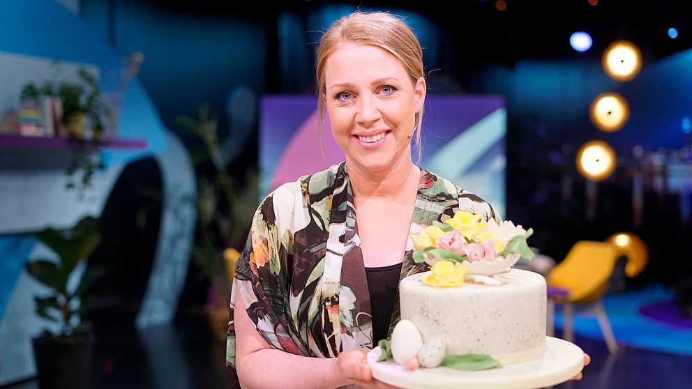 Tårtexperten Johanna Viberg håller en påskdekorerad tårta med sockerblommor.