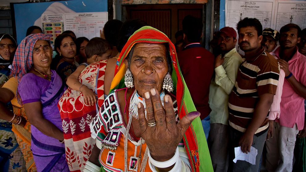 En kvinna visar upp bläcket på sitt finger efter att hon röstat.